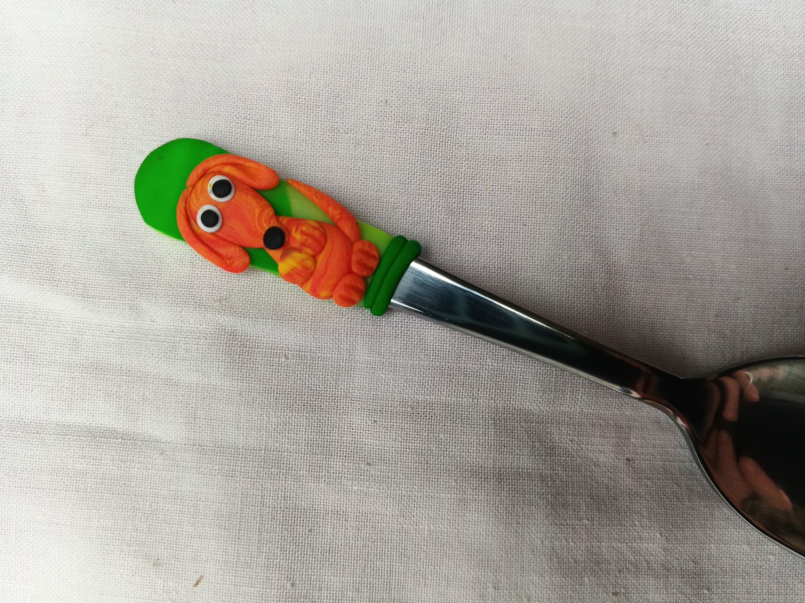 Oranžový jezevčík modelovaný na krátké mocca lžičce vhodný do nízkého šálku. Délka lžičky 11cm