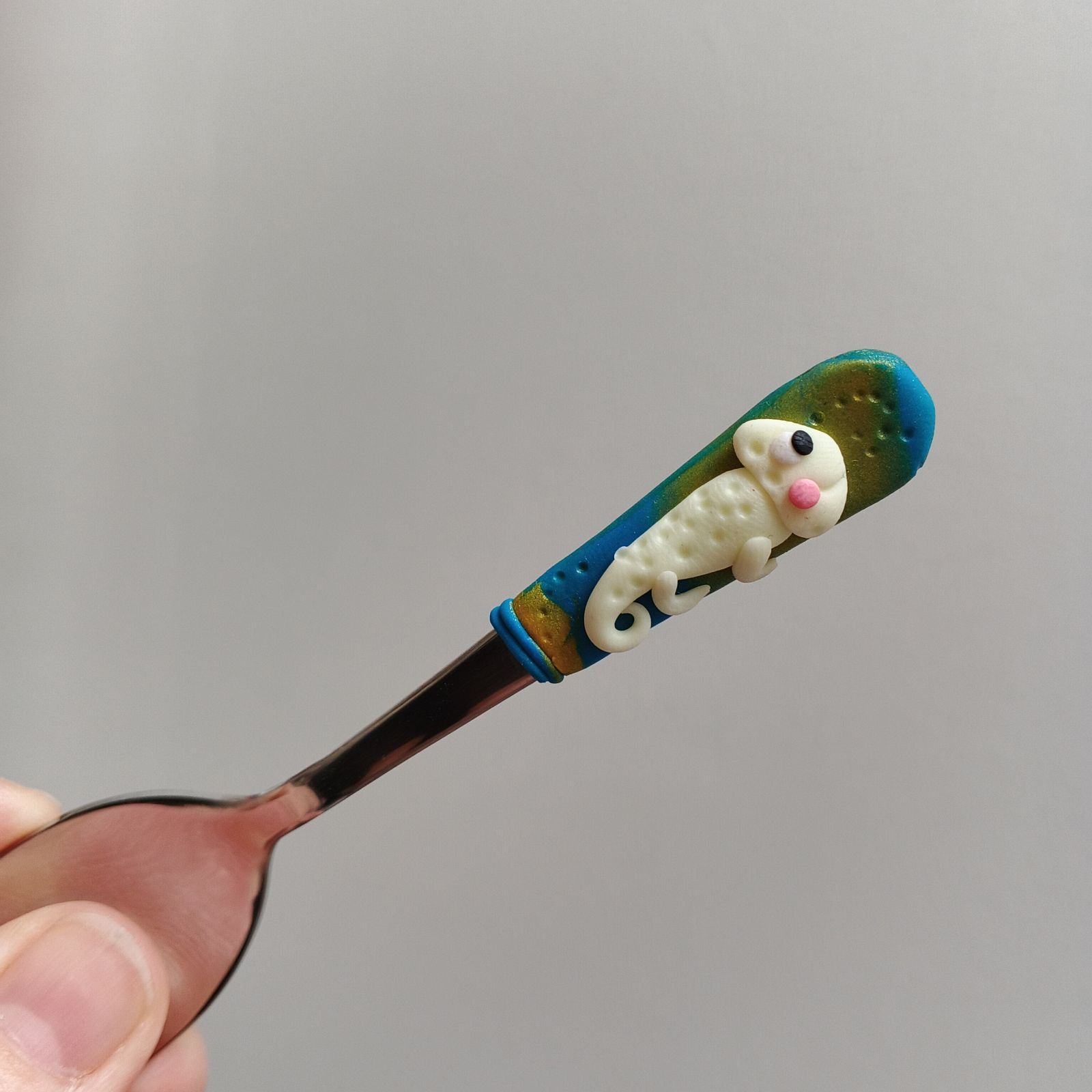 Veselý fosforeskující svítící chameleon na krátké Mocca lžičce - modrozlaté pozadí