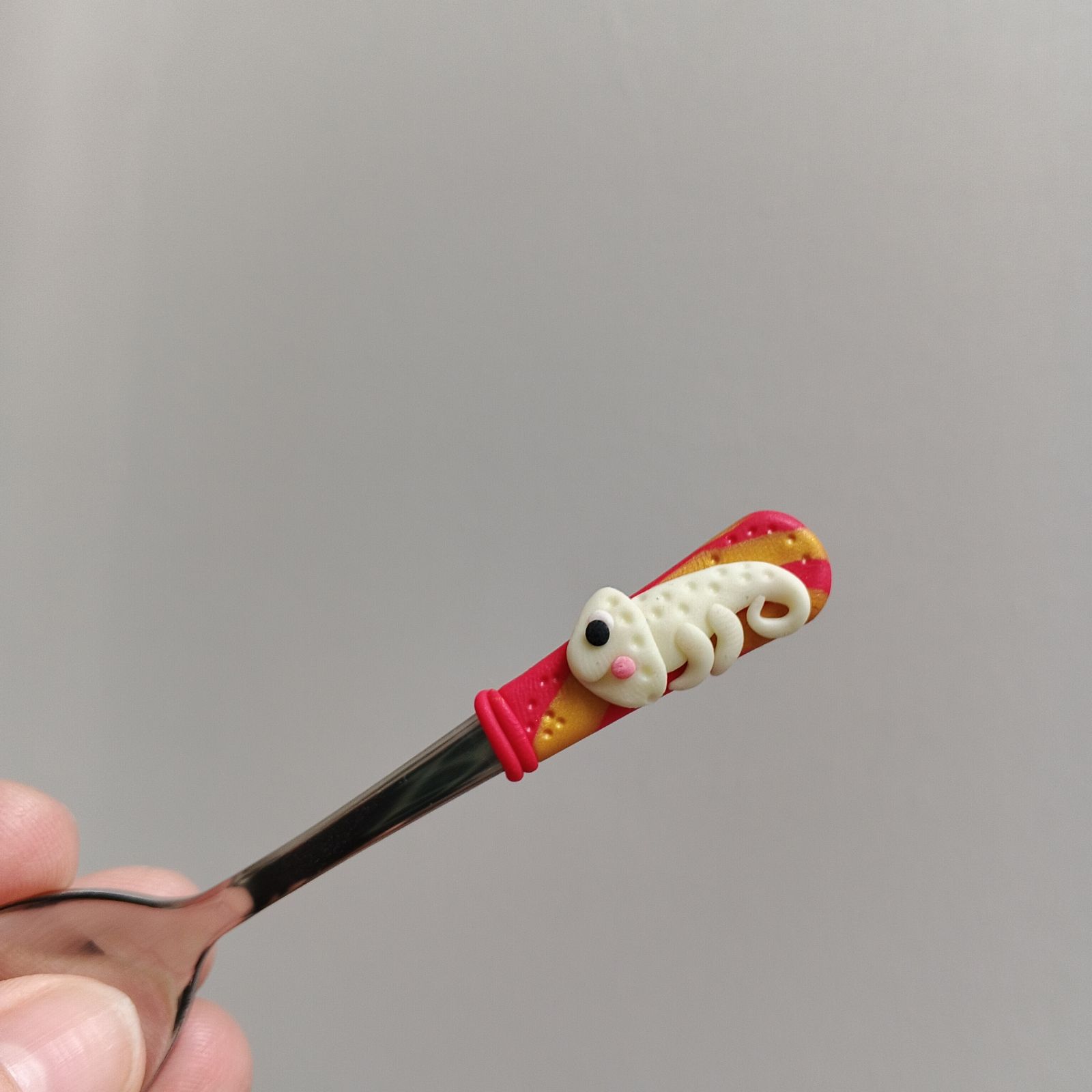 Veselý fosforeskující svítící chameleon na krátké Mocca lžičce - červenozlaté pozadí