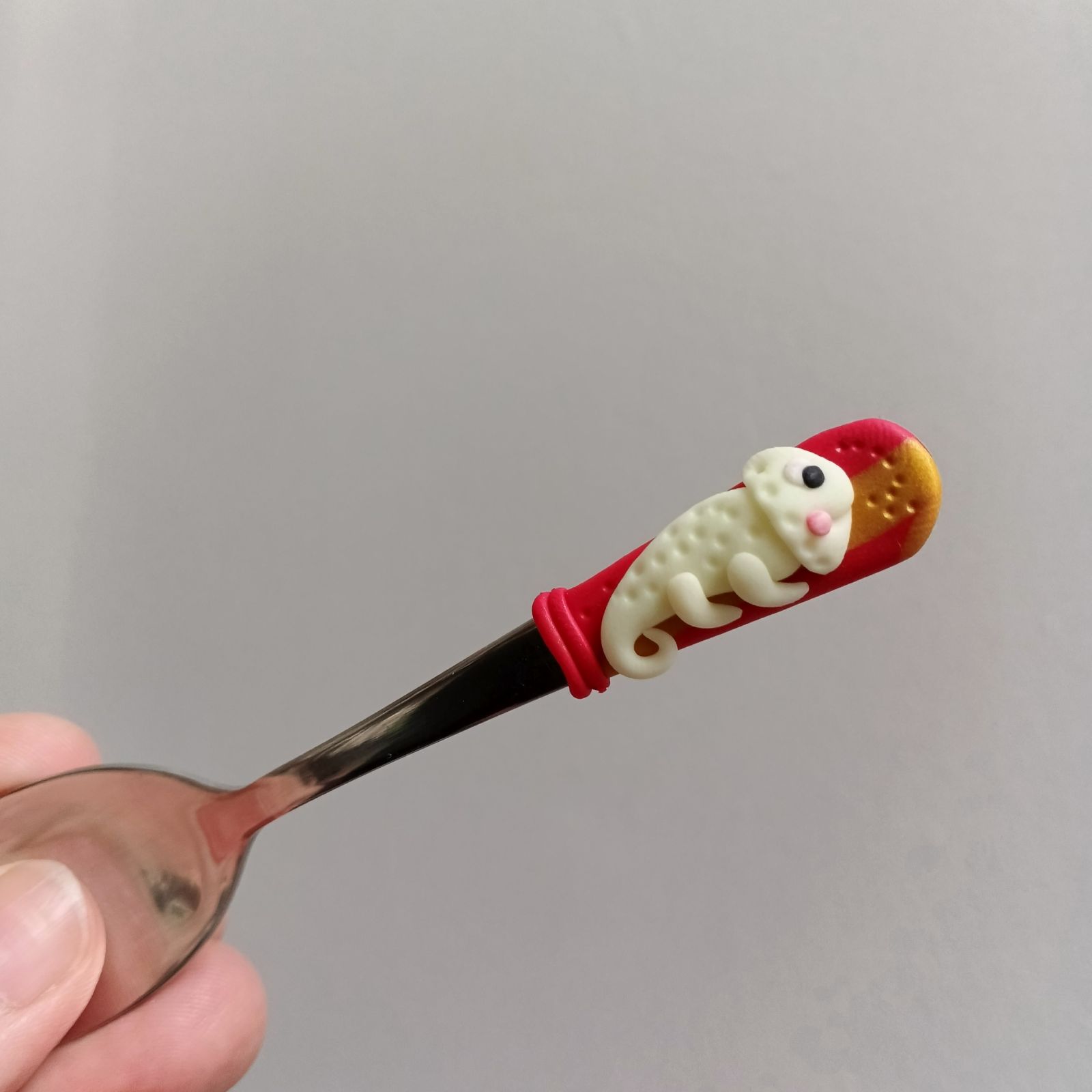 Veselý fosforeskující svítící chameleon na krátké Mocca lžičce - červenozlaté pozadí