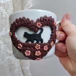 Pro radost a potěšení. Velký hrnek s kráčející černou kočkou mezi zrnky kávy. Akorát do ruky, málo kónický, se srdíčkem tvořeným kávovými zrnky,  květinami a lístky. Obsah hrnku 36cl