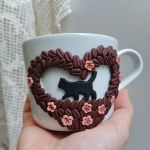 Pro radost a potěšení. Velký hrnek s kráčející černou kočkou mezi zrnky kávy. Akorát do ruky, málo kónický, se srdíčkem tvořeným kávovými zrnky,  květinami a lístky. Obsah hrnku 36cl