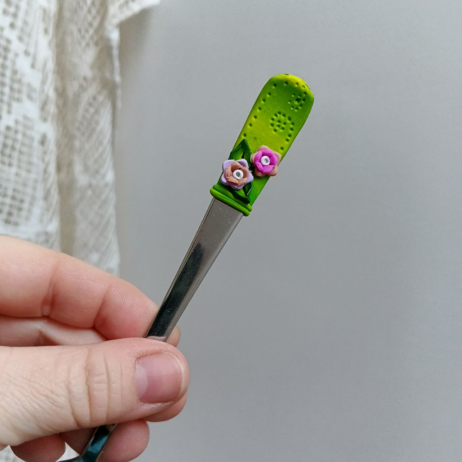 Světlezelený podklad s pestrobarevnými květinkami a zelenými lístečky - koktejlová lžička