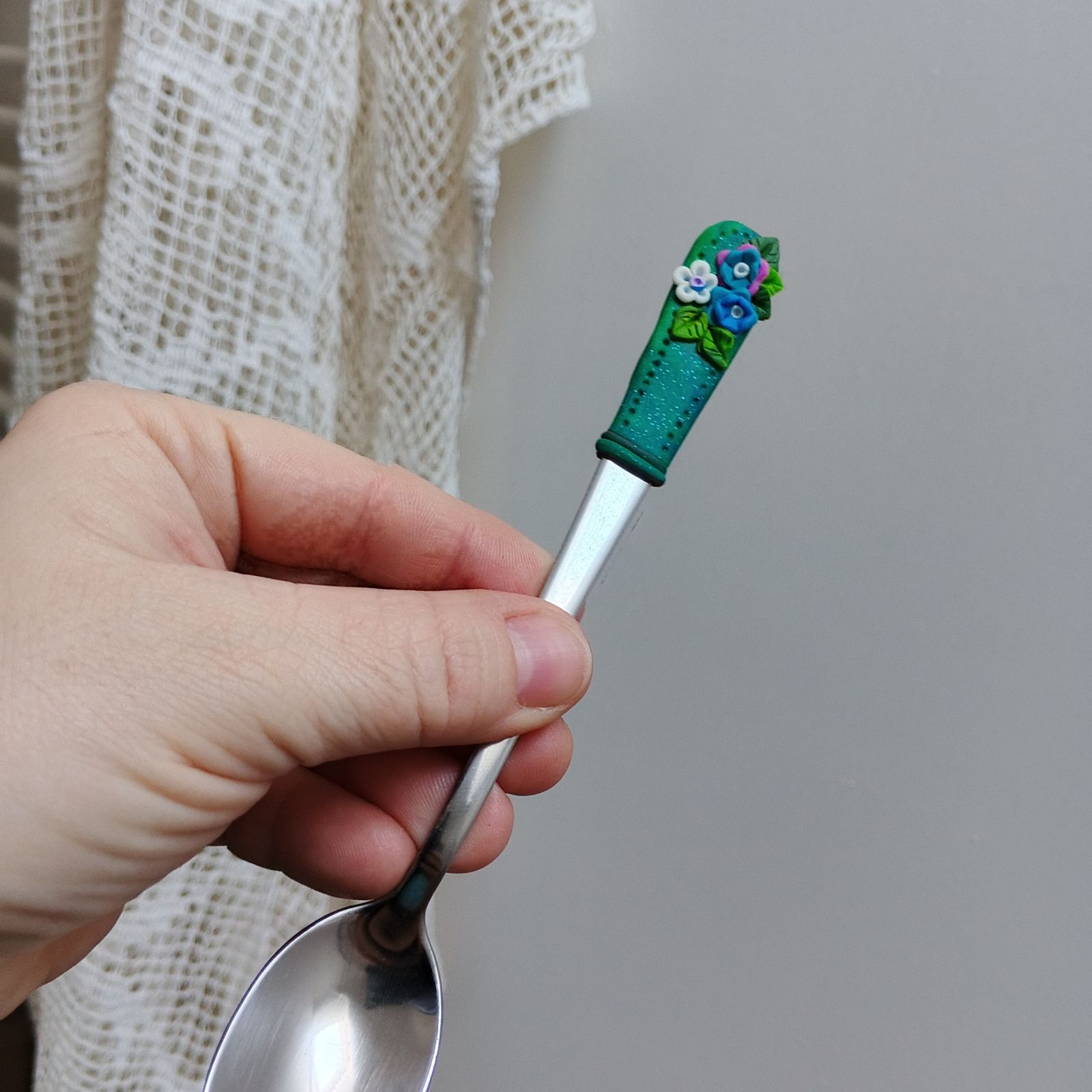 Tmavě zelený podklad s barevnými květinkami a zelenými lístečky - koktejlová lžička