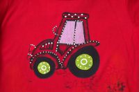 Ručně malovaný traktor se zelenými koly na červeném tričku s krátkým rukávem a vrstveným efektem velikost 116